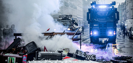 Wasserwerfer vor improvisierter Barrikade in Leipzig am Samstag