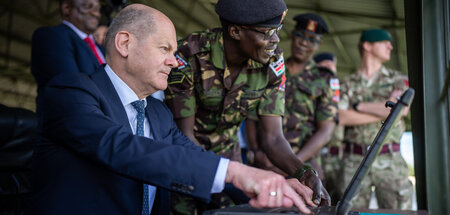 Olaf Scholz löst an einem ferngesteuerten Roboter via Computer e...