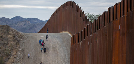 Migranten aus Zentral- und Südamerika an der Grenzmauer (im US-B...