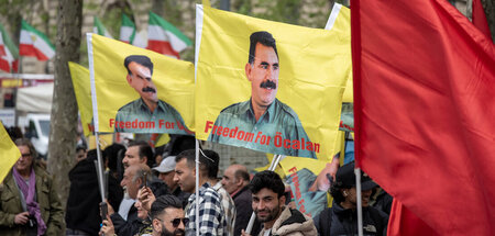 Fahnen mit dem Bild des inhaftierten Abdullah Öcalan auf einer K...