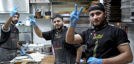 Syrische Köche in der Küche eines Berliner Restaurants freuen si...