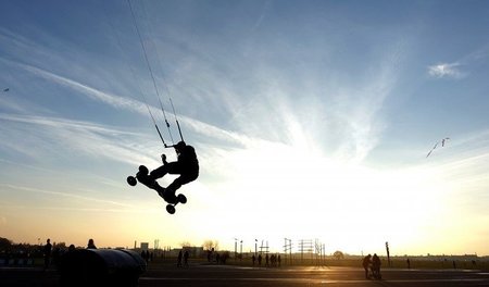 Neujahrssprung: Ein Skateboarder steigt mit seinem Drachen am Te...