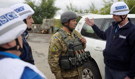 OSZE-Mitarbeiter unterhalten sich mit ukrainischem Militär (Sept...