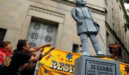 Menschenrechtsaktivisten reißen eine Statue von US-Justizministe...